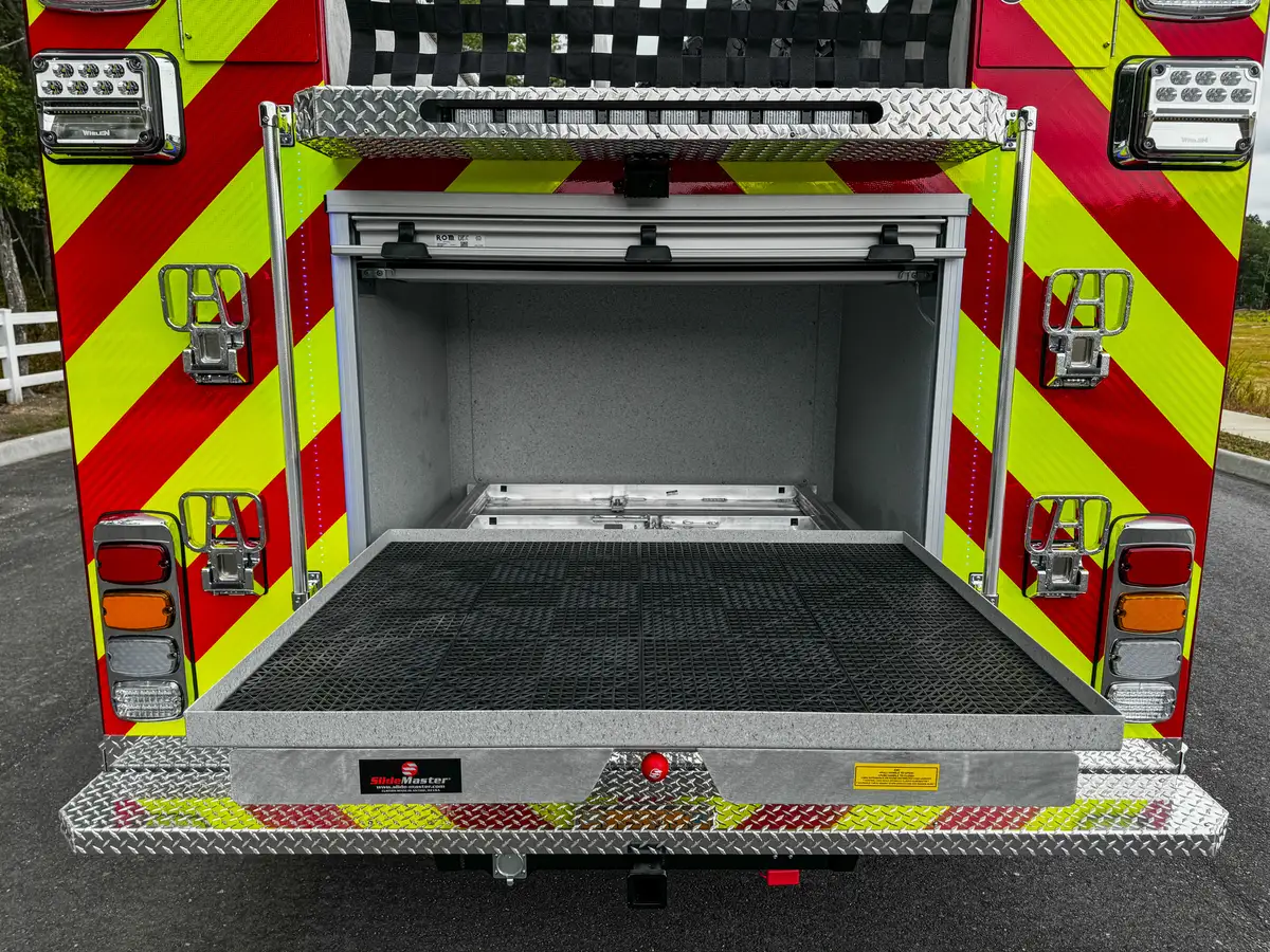 Rear compartment open three-quarter view with tailboard and interior shelf.